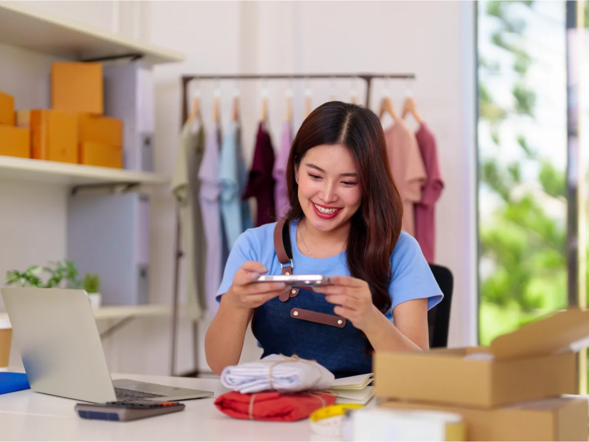 Small business owner checking her phone behind the counter